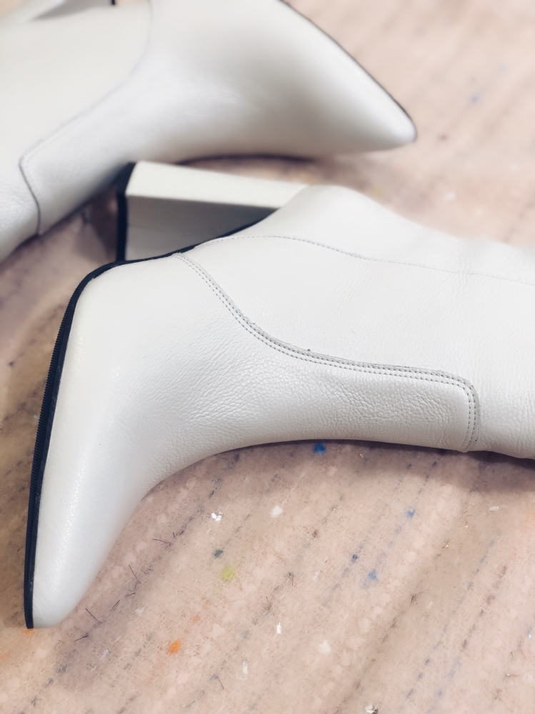 Białe skórzane kozaki na słupku